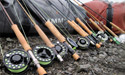 collection of fly rods resting on gear bags