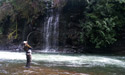 angler with bent fishing rod and waterfall background